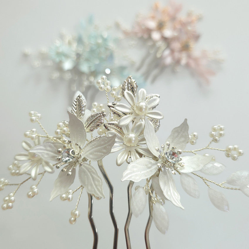 Decorative floral hair pins with pearls on a light background