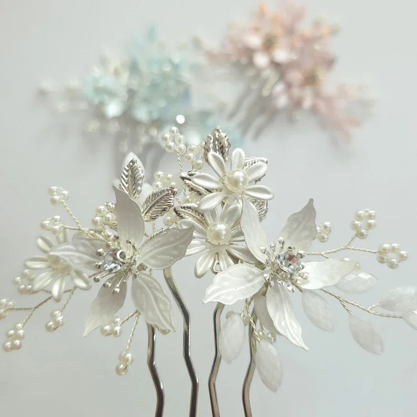 Decorative floral hair pins with pearls on a light background