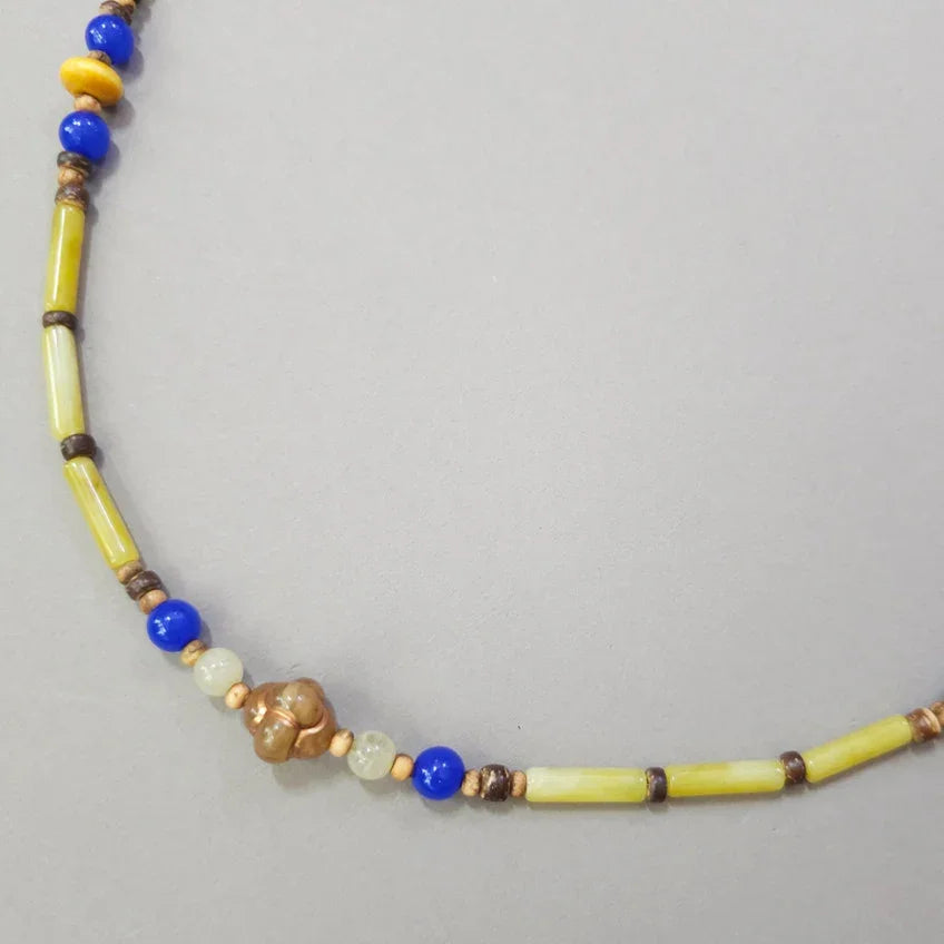 A Native Korean natural stone Gat string featuring yellow, blue, and brown beads.