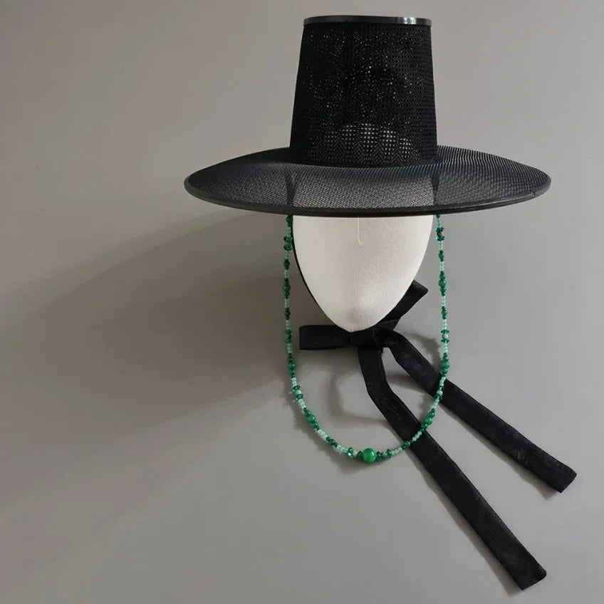 Green natural stone Gat string attached to a black traditional Korean Gat hat by Native Korean.