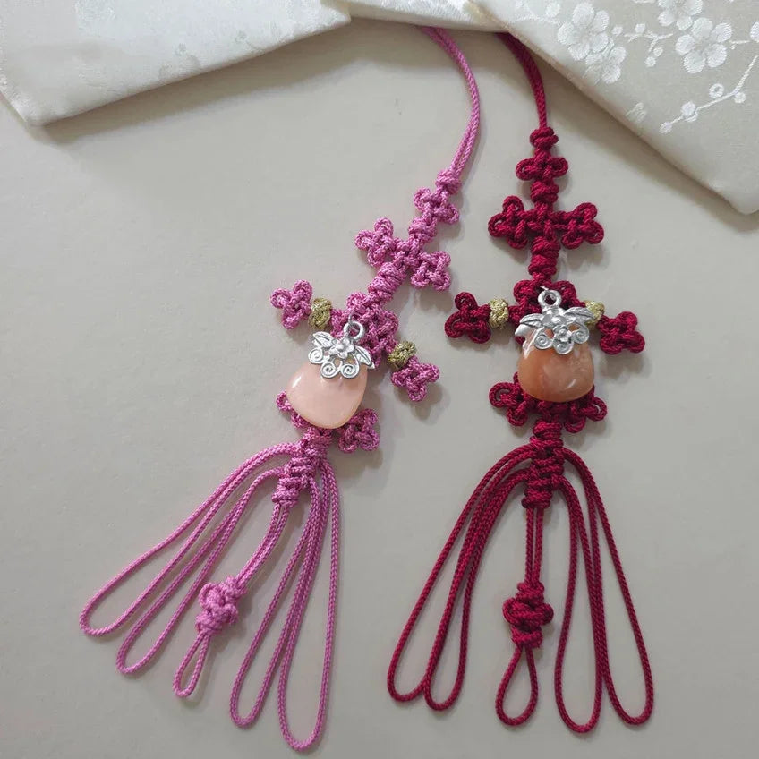 Pink and red Native Korean Norigae with knotted details and stone charms.
