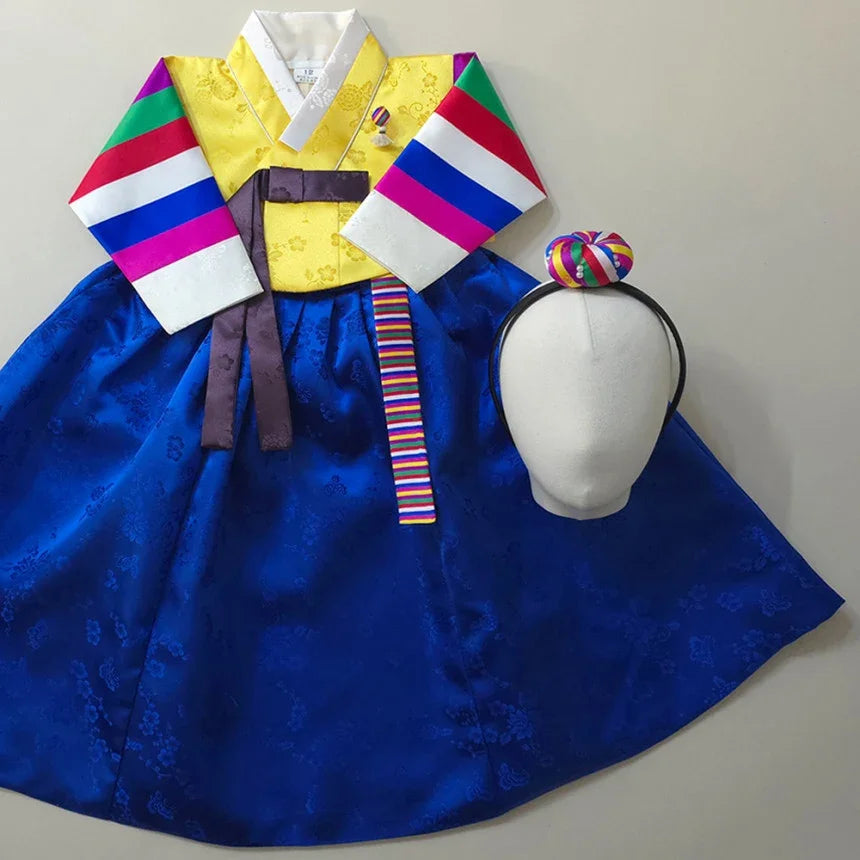 Girl Hanbok featuring a yellow saekdong jeogori with colorful sleeves and a blue skirt.