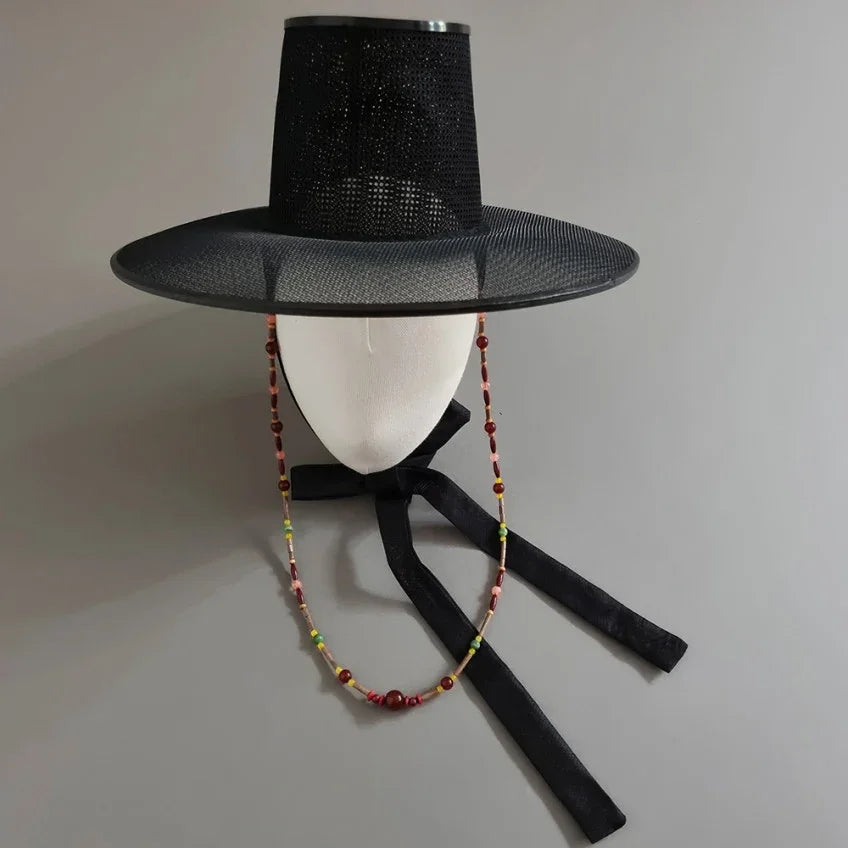 Native Korean Natural Stone Gat String in brown on a traditional black Gat hat
