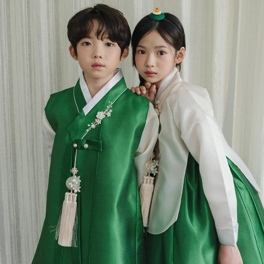 Boy and girl wearing Native Korean green and white hanbok with norigae accessories.