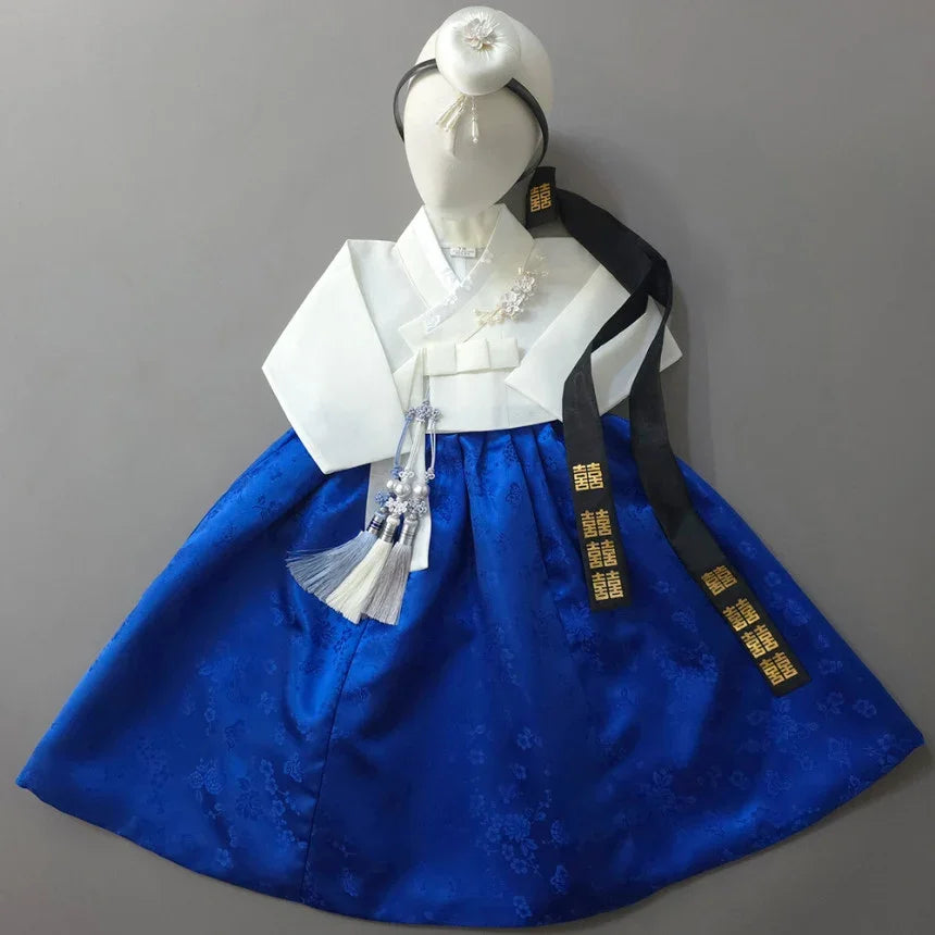 Native Korean Heejin Girl Hanbok with white jeogori, blue skirt, jokduri, daenggi, and norigae.