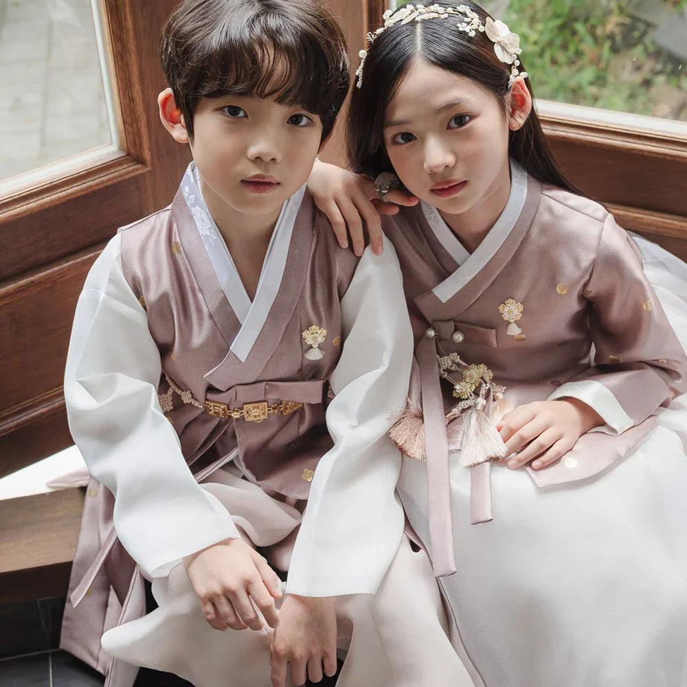 Boy and girl wearing brown Native Korean hanbok with traditional norigae accessories.