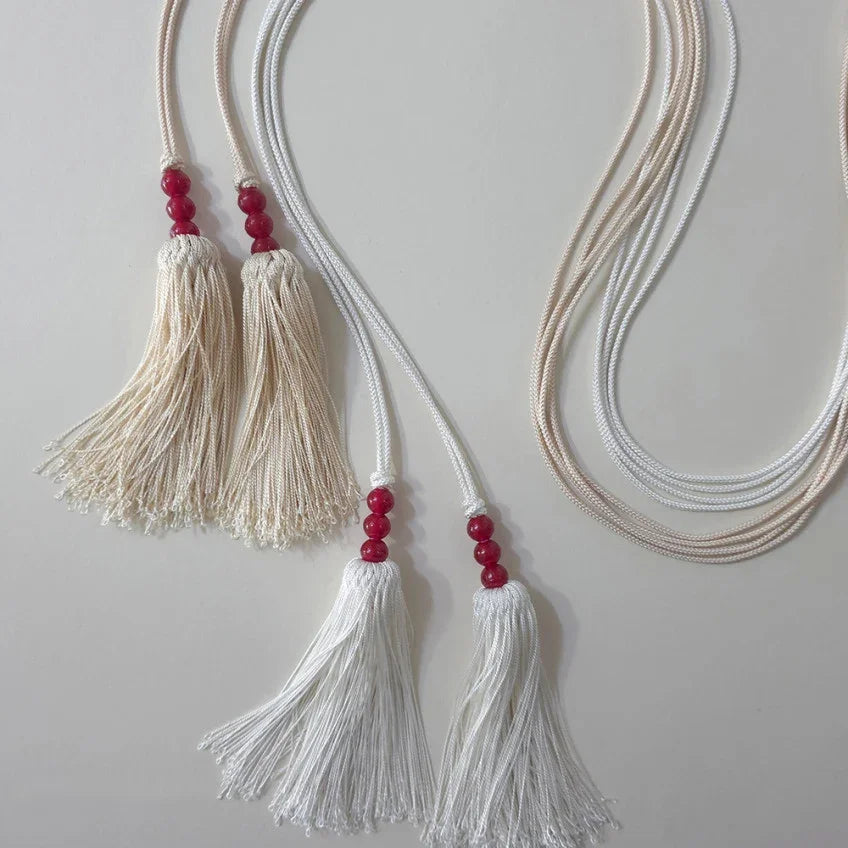White and cream Native Korean Gunyun tassel belts with red beads.