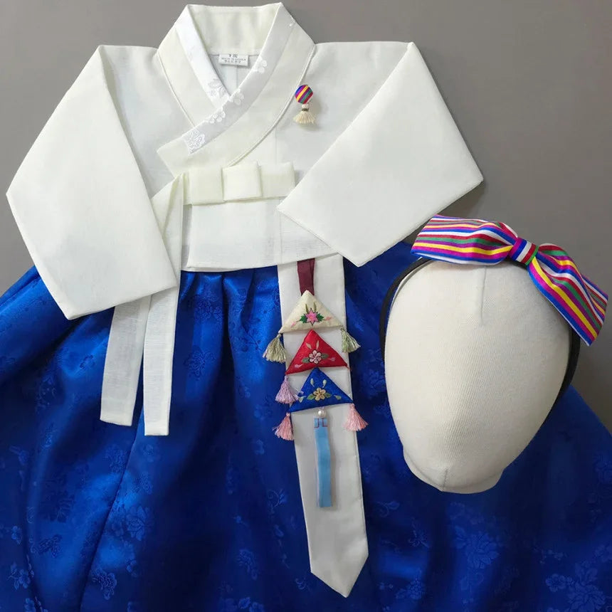 Native Korean Heejin Girl Hanbok featuring a white jeogori, blue skirt, norigae, and headband.