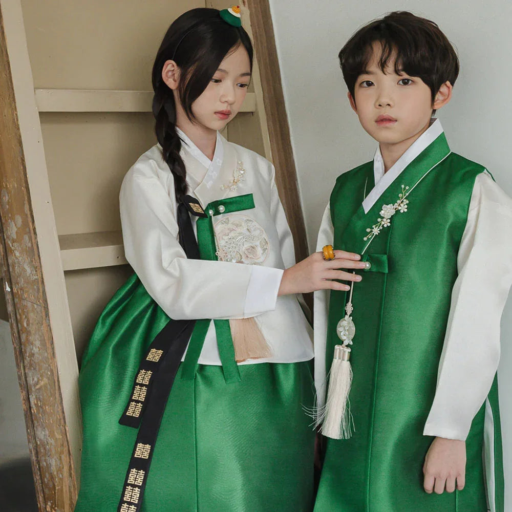 Children wearing Native Korean girl and boy hanbok in white and green with norigae accessories.