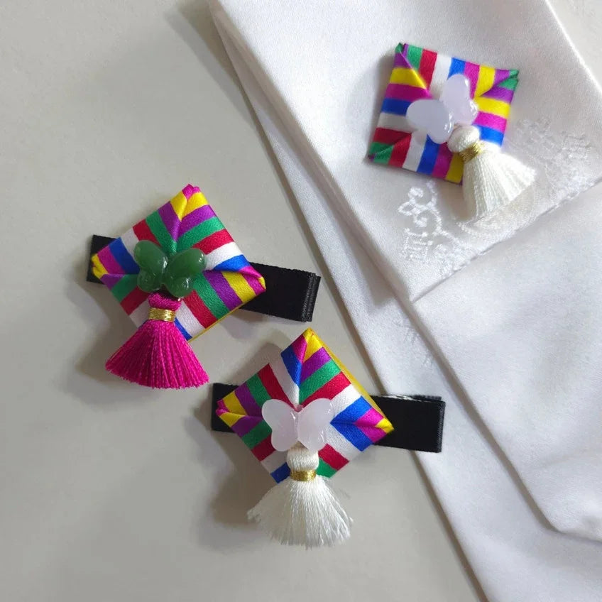 Three Native Korean Saekdong Ddakji hairpins with colorful stripes and tassels.