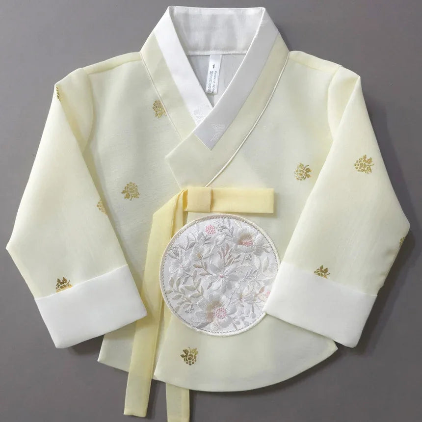 Pale yellow Native Korean girl hanbok jacket with floral embroidery and white cuffs.