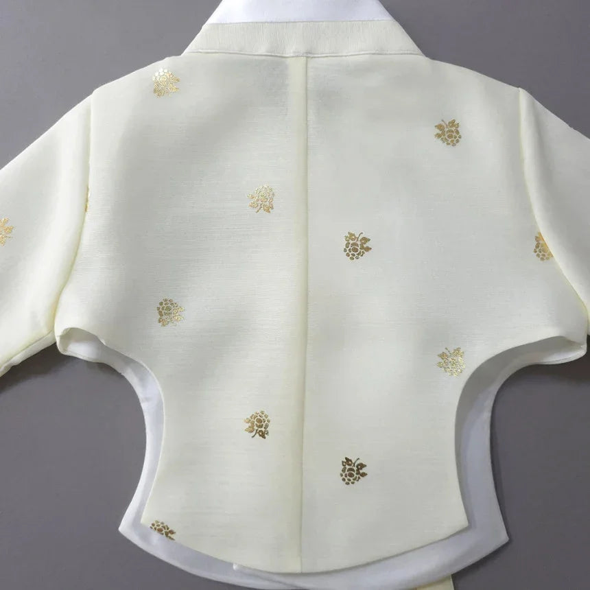 Back view of a cream-colored Native Korean Girl Hanbok jacket with gold floral patterns.