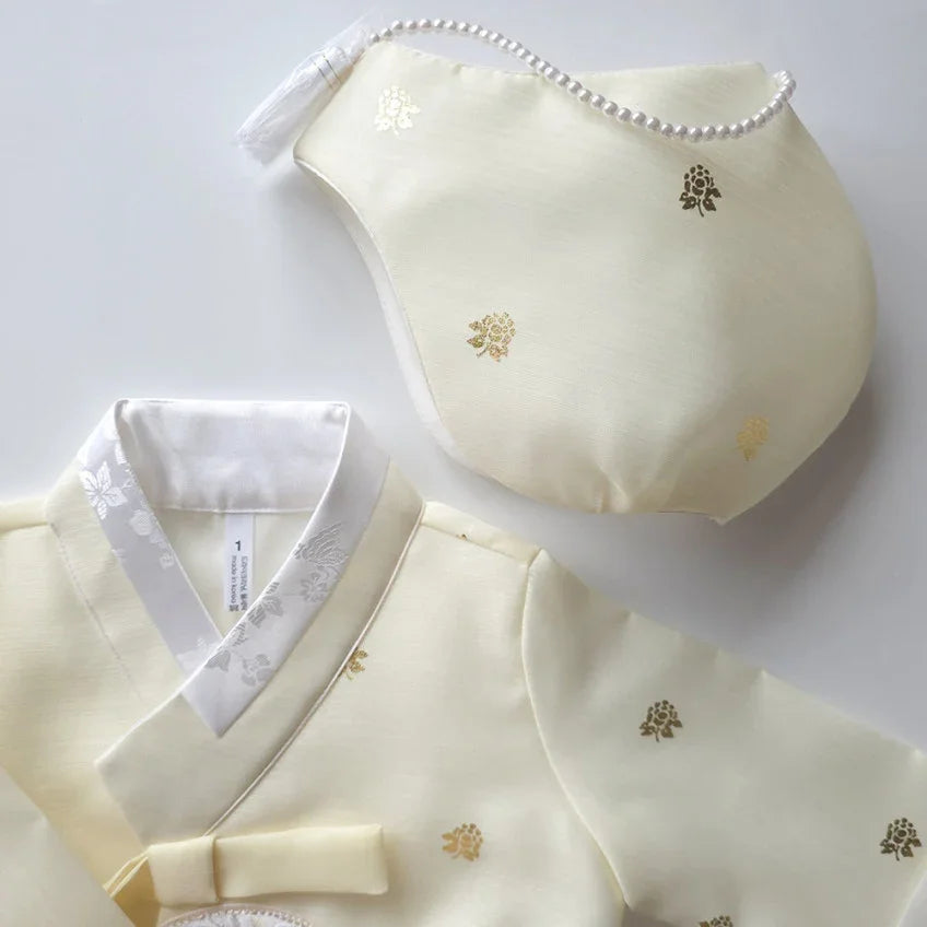 Cream-colored Native Korean hanbok and matching Jobawi with gold floral patterns.