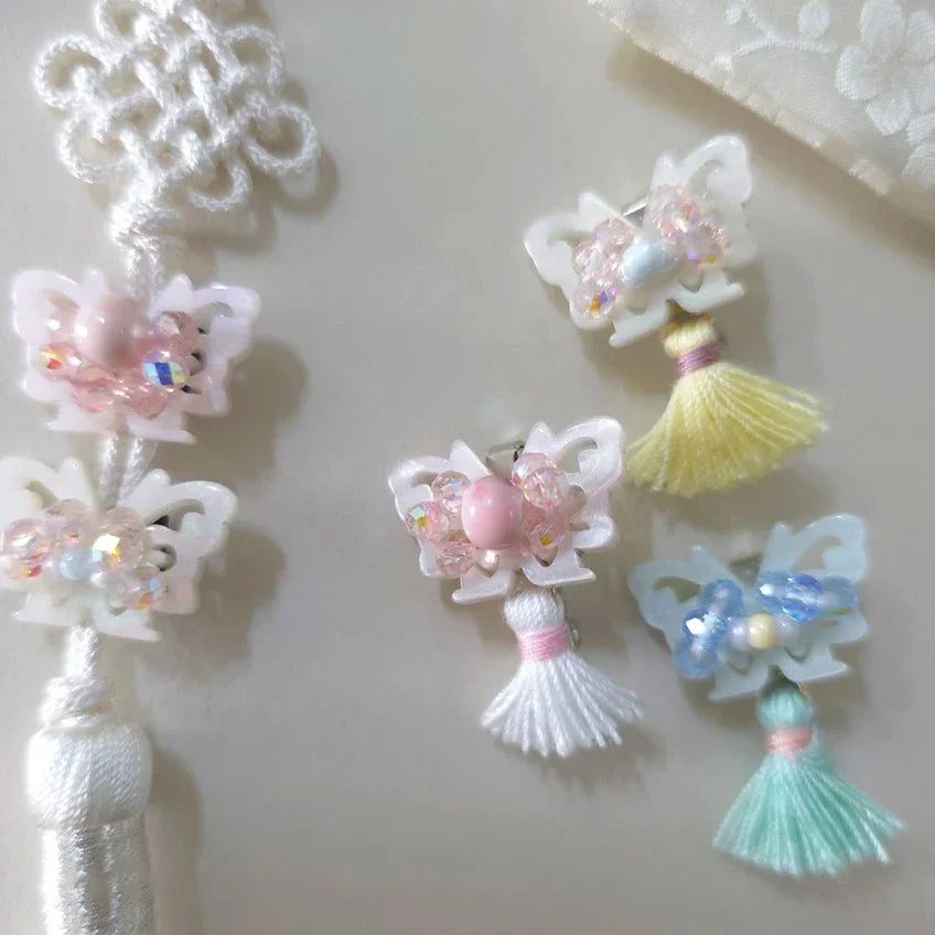 Assorted Native Korean crystal butterfly tassel brooches in pastel colors.