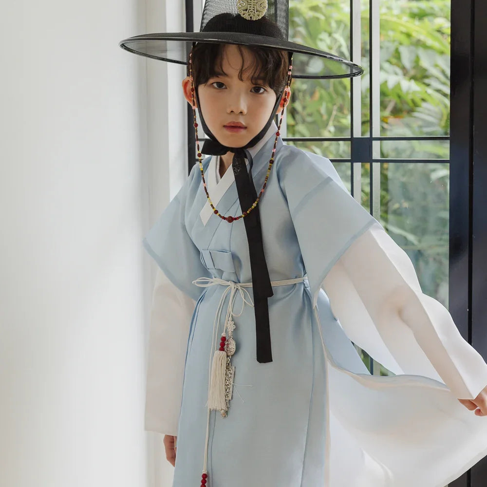 Boy wearing a light blue Native Korean Gunyun Sky Dopo boy hanbok and a traditional Gat hat.