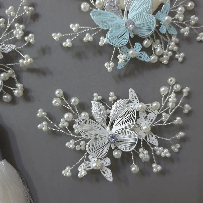 White and light blue butterfly brooches by Native Korean with pearl and wire accents.