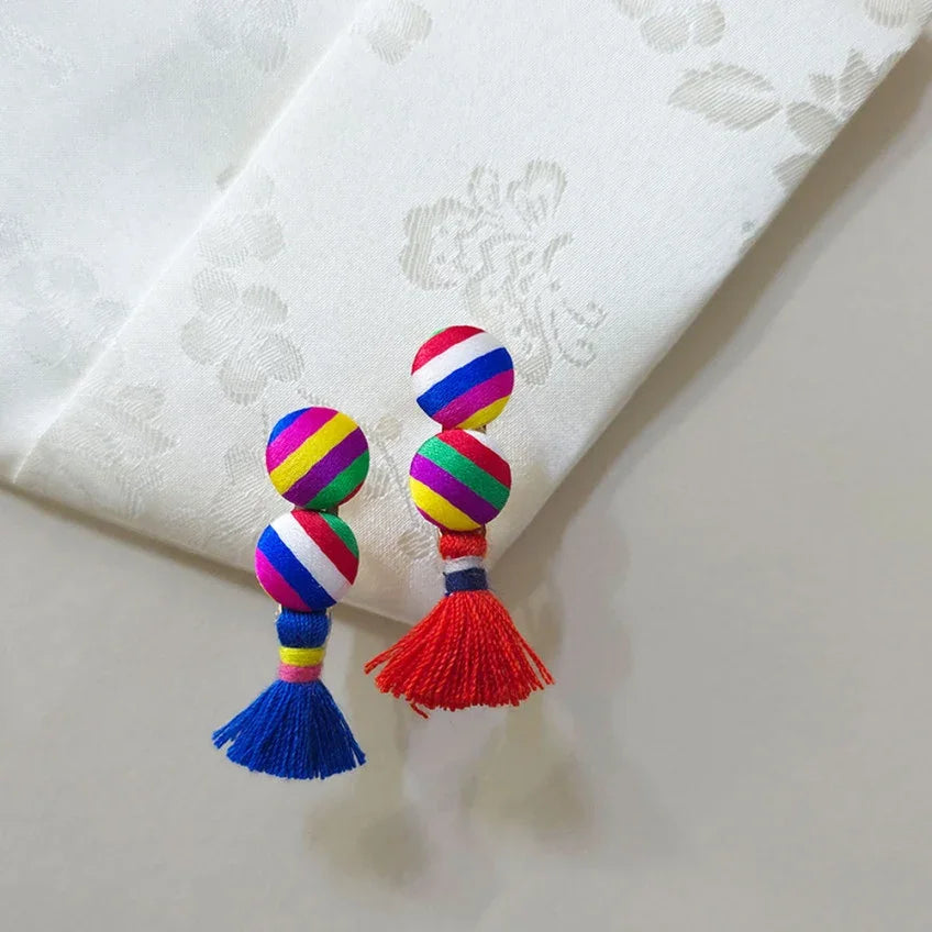 Two Native Korean Duo Saekdong brooches with colorful striped beads and tassels.