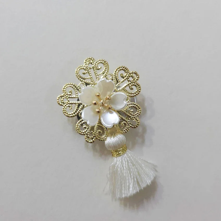 Native Korean Bloom Tassel Brooch featuring a gold filigree frame and white flower design.
