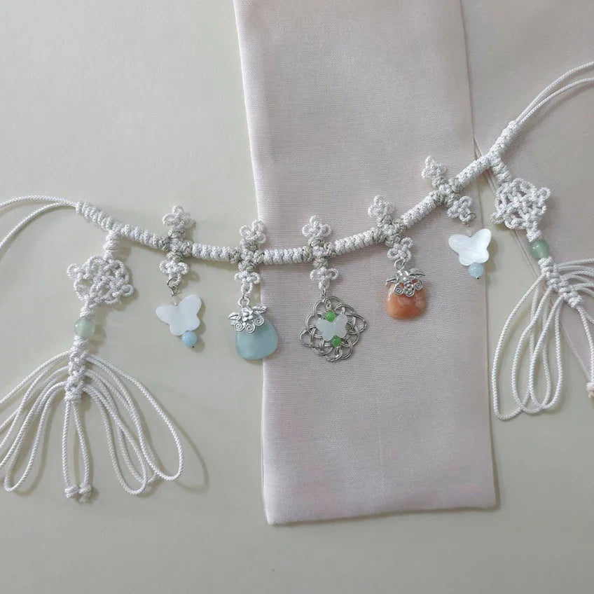 White knotted Norigae charm belt by Native Korean with butterfly and jade pendants.