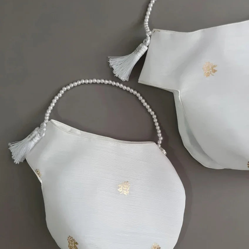 Two white Native Korean Yebon Jobawi with gold floral embroidery and pearl strap details.