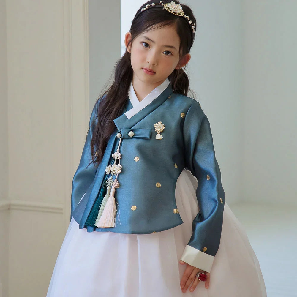 A young girl wearing a teal Native Korean Girl Hanbok with a Norigae and a floral headband.