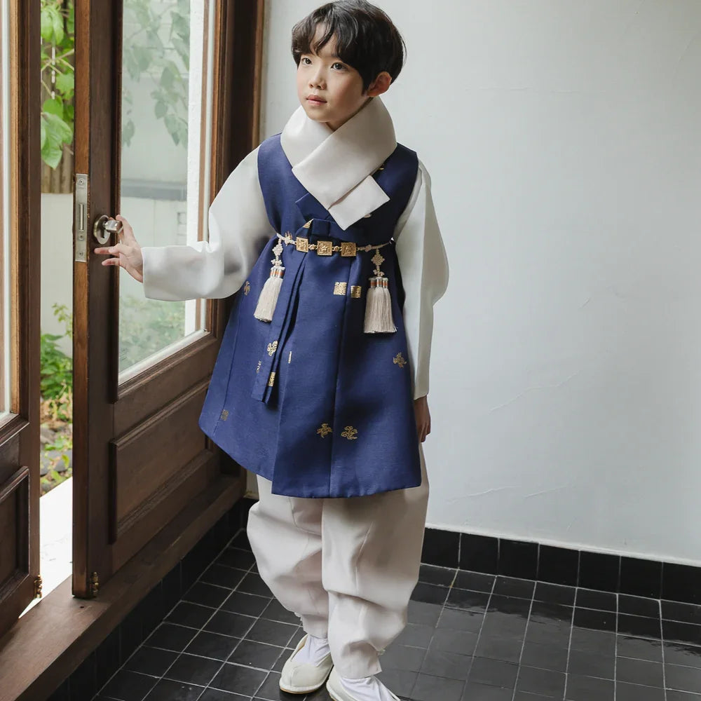 A young boy wearing a Native Korean navy blue and white Boy Hanbok with a gold Norigae.