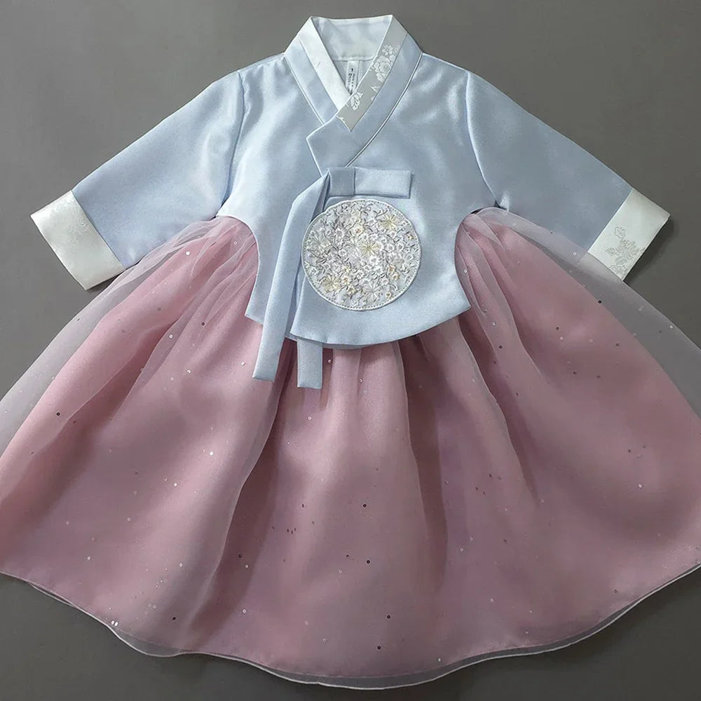 Native Korean Girl Hanbok featuring a light blue jeogori with floral embroidery and a pink skirt.