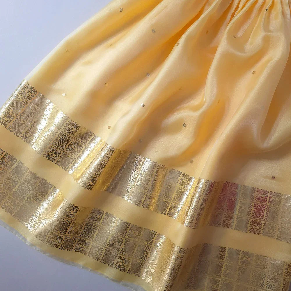 Close-up of the yellow fabric and gold embroidered trim of a Myoung Girl Hanbok.
