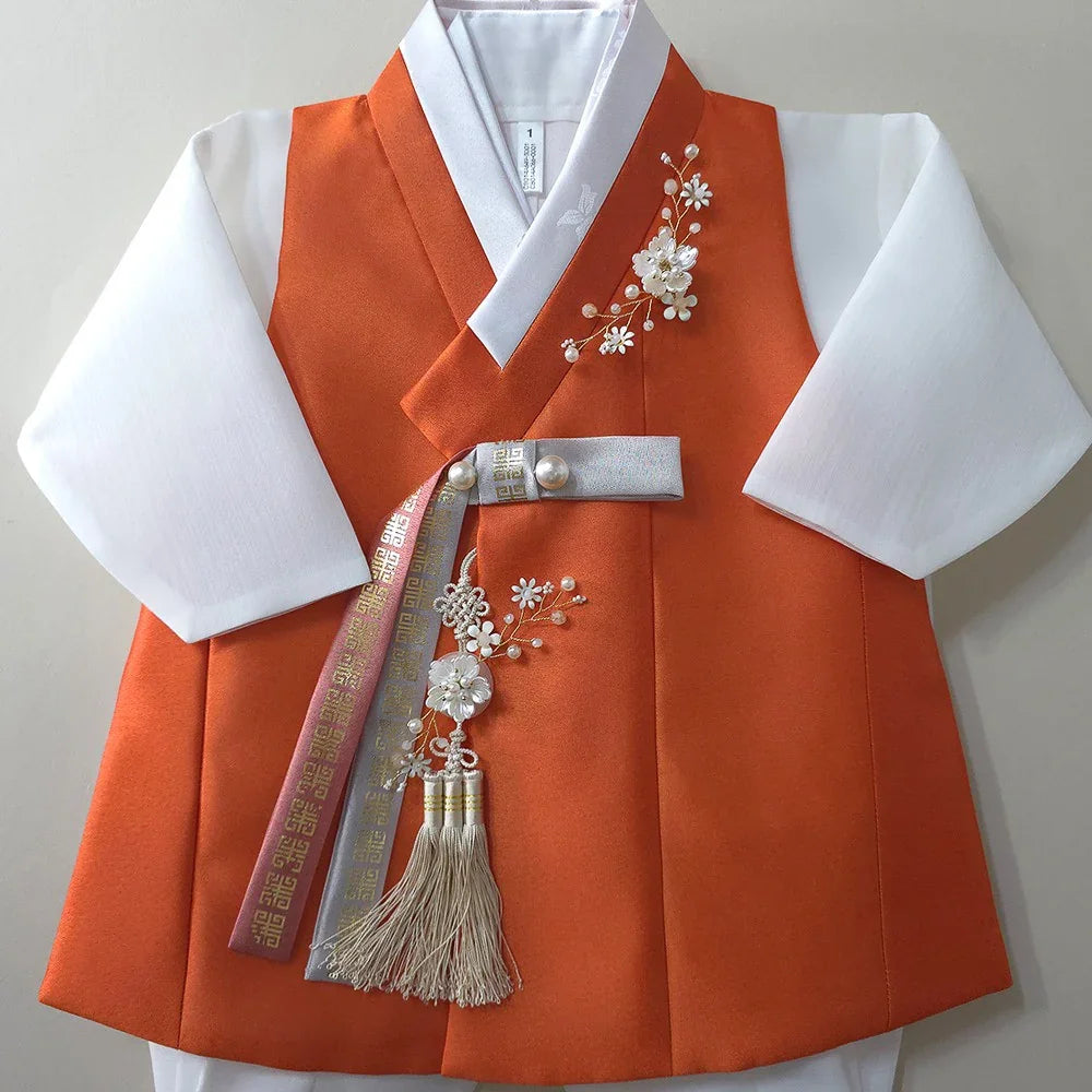Eunkyo Coral Vest Boy Hanbok by Native Korean with white sleeves and a decorative Norigae.