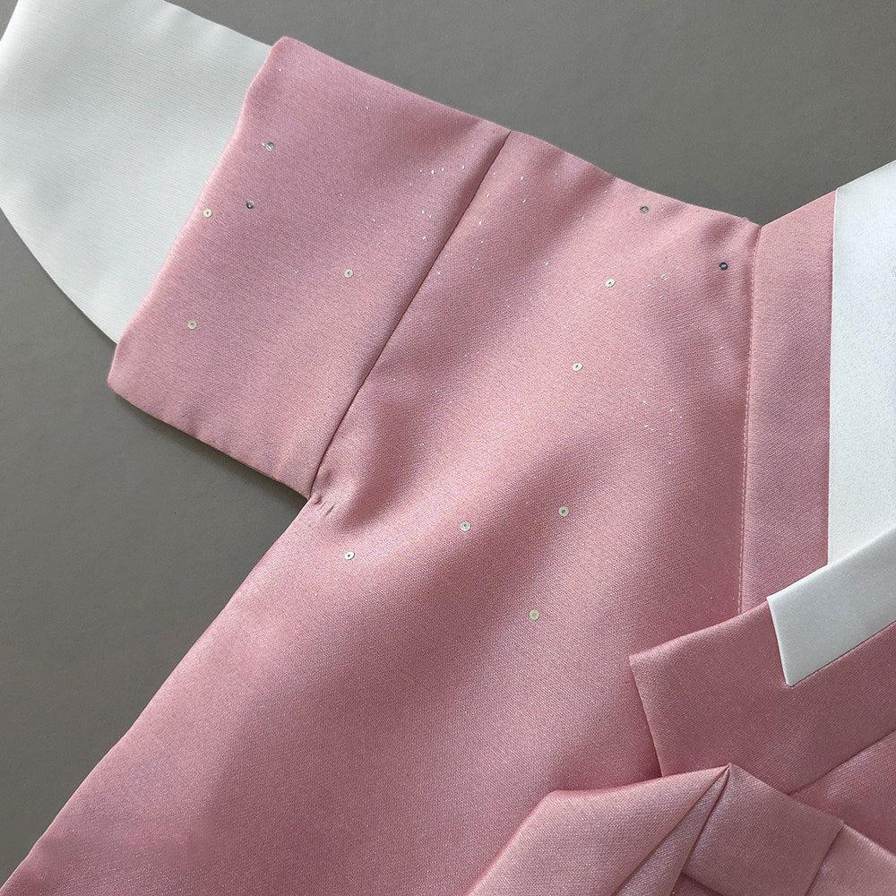 Close-up of the pearl pink fabric and shimmering details of a Native Korean Boy Hanbok.