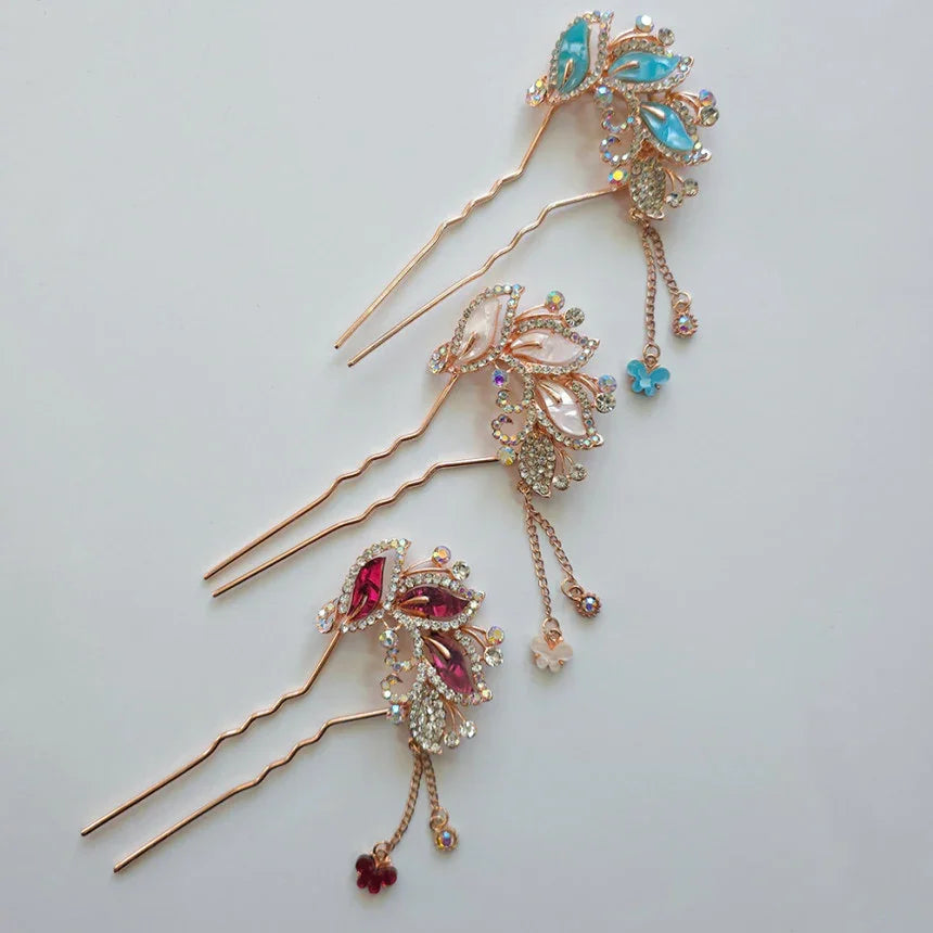 Decorative hair pins with gemstones on a light gray background