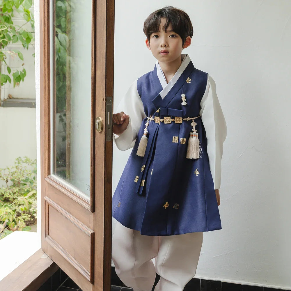 Young boy wearing a navy blue and white Native Korean Boy Hanbok with traditional gold accents.