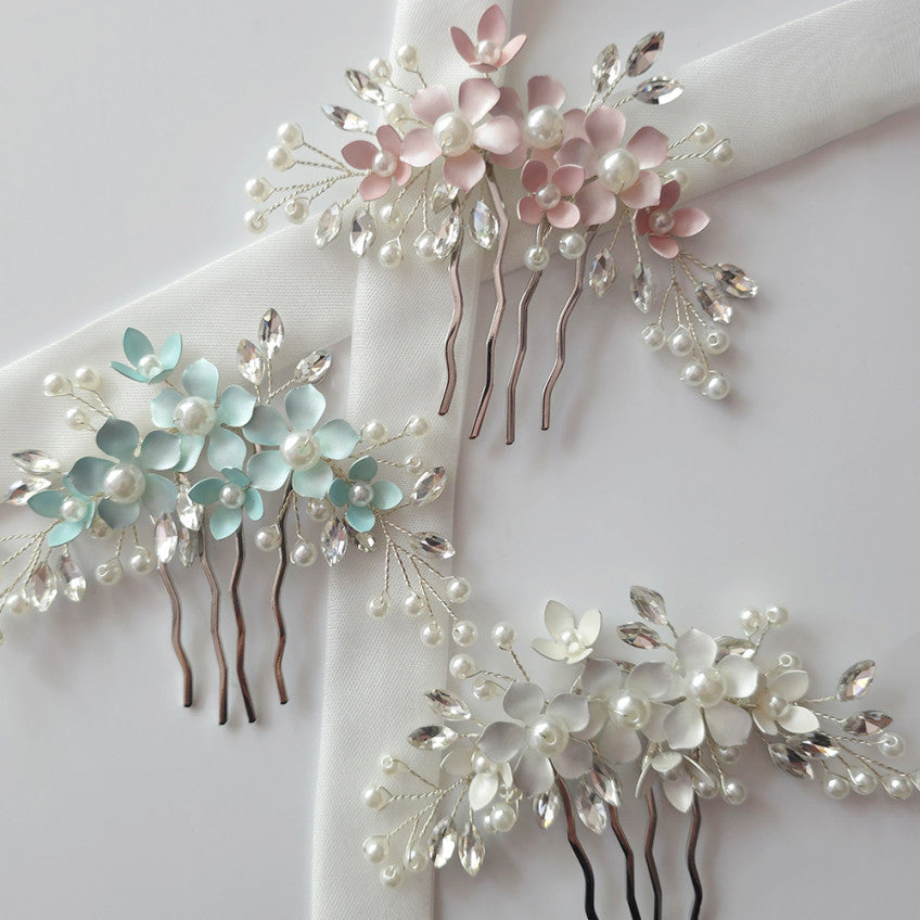 Three floral hair combs with pearls on a white background