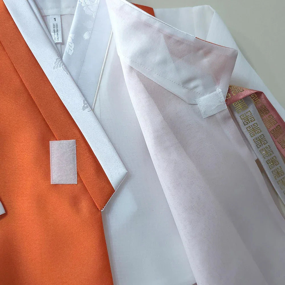 Close-up detail of a coral and white Native Korean Boy Hanbok vest showing stitching and labels.