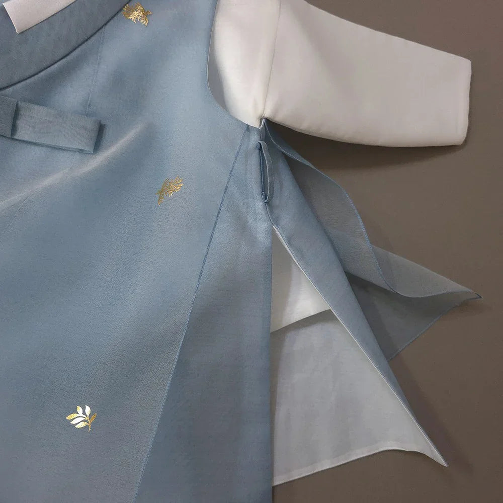 Close-up of a sky blue Native Korean Boy Hanbok with gold foil leaf patterns.