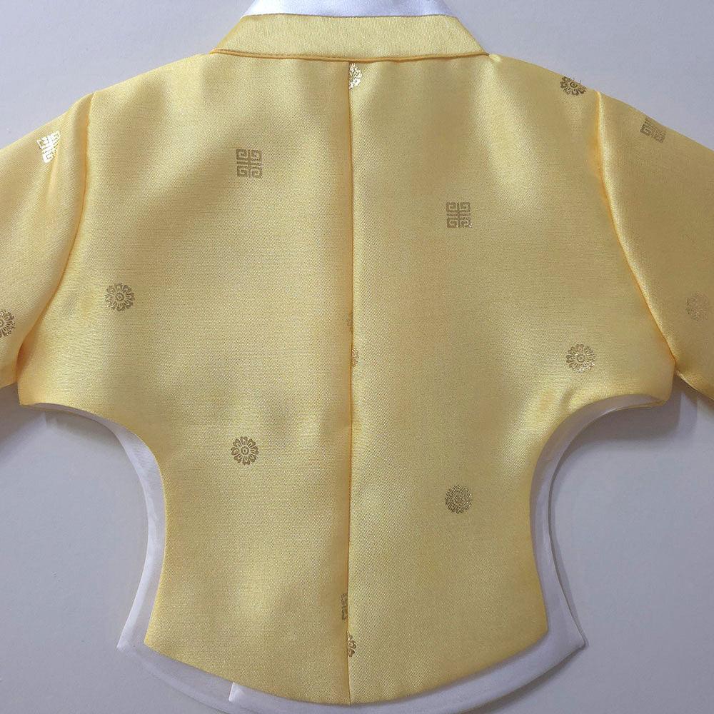 Back view of a yellow Native Korean girl hanbok jacket with gold floral and geometric patterns.