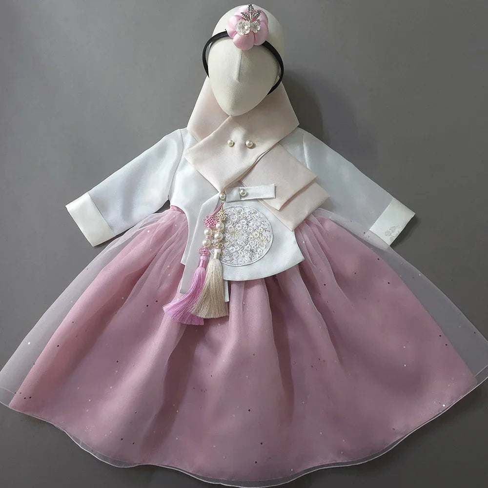 Pearl Pink Girl Hanbok by Native Korean with a matching headpiece and Norigae accessory.